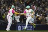 San Diego Padres' Jake Cronenworth celebrates with third base coach Tim Leiper after hitting a home run during the eighth inning of a baseball game against the Atlanta Braves Friday, March 28, 2025, in San Diego. (AP Photo/Gregory Bull)