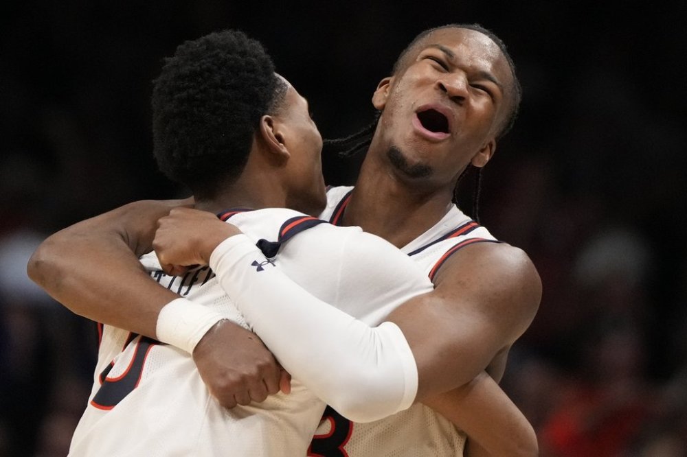 Auburn's Tahaad Pettiford, left, and Miles Kelly (13) celebrate a win over Michigan State after the Elite Eight of the NCAA college basketball tournament, Sunday, March 30, 2025, in Atlanta. (AP Photo/Brynn Anderson)