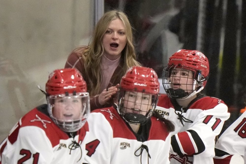 Milwaukee School of Engineering head coach Baylee Marabella, top, cheers during a women's Division III NCAA college hockey game against Wake Forest College, Friday, Feb. 14, 2025, in Milwaukee. (AP Photo/Morry Gash)