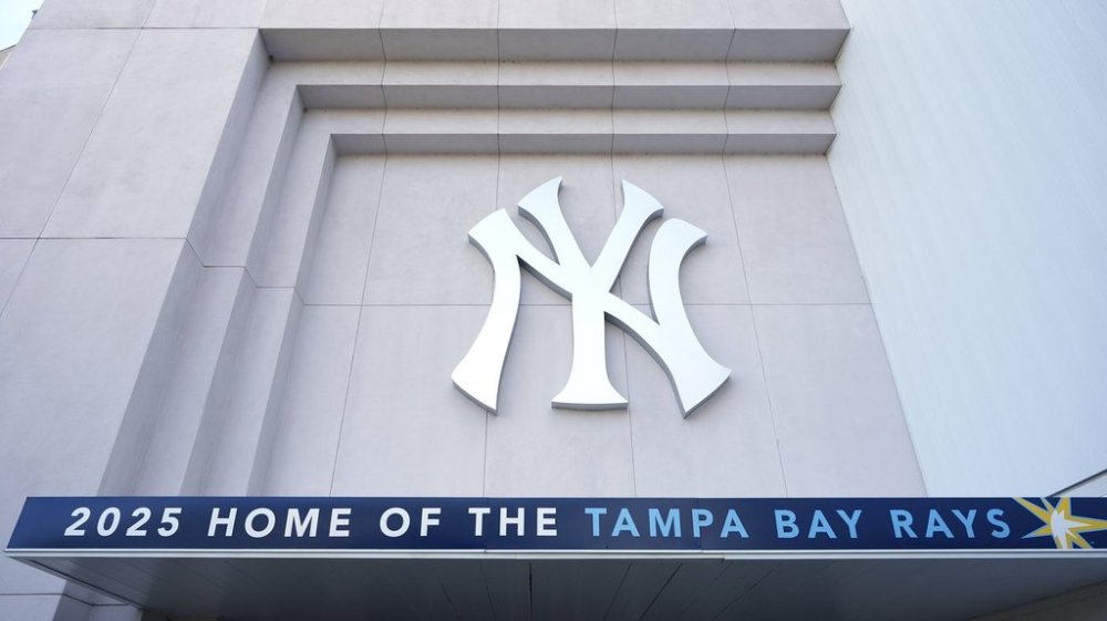 A Tampa Bay Rays banner hangs near a New York Yankees logo outside George M. Steinbrenner Field during a stadium tour Wednesday, March 26, 2025, in Tampa, Fla. (AP Photo/Chris O'Meara)