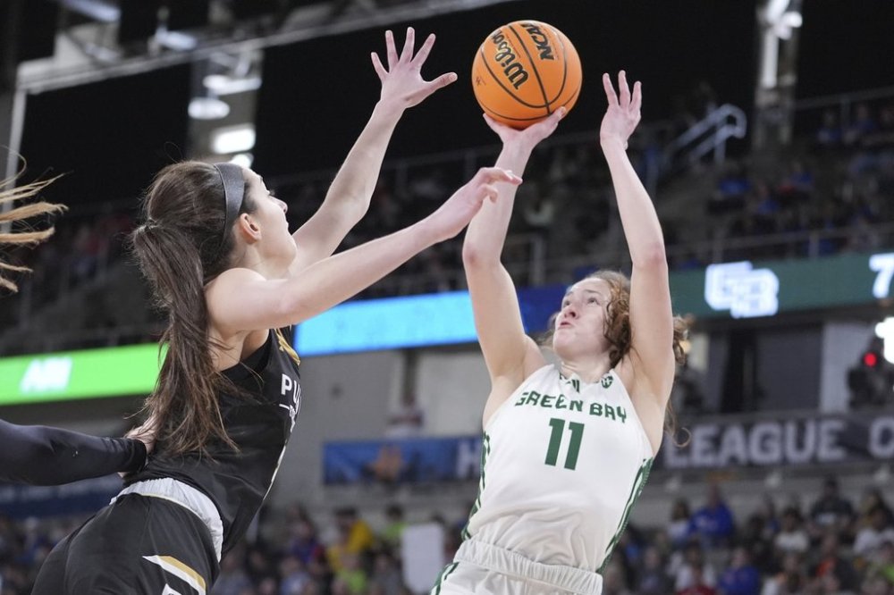 Green Bay guard Natalie McNeal (11) shoots over Purdue Fort Wayne guard Amellia Bromenschenkel (13) during the first half of an NCAA college basketball game in the championship of the Horizon League tournament in Indianapolis, Tuesday, March 11, 2025. (AP Photo/Michael Conroy)