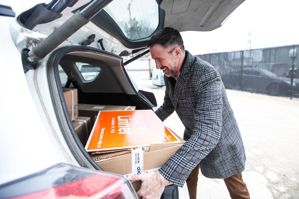 MIKAELA MACKENZIE / FREE PRESS
NDP candidate Thomas Linner picks up lawn signs to distribute as the federal election campaign picks up steam.