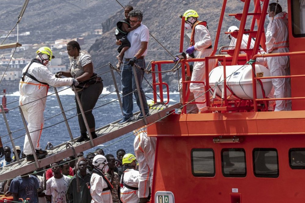 FILE - Migrants disembark at the port of