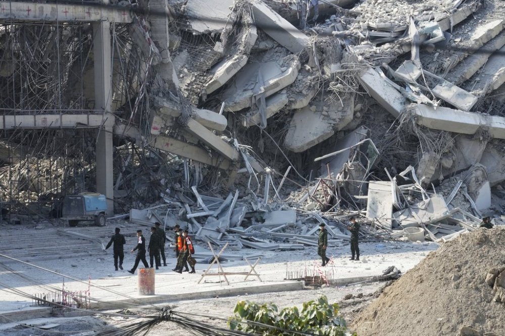 Rescuers walk at the site of a high-rise building under construction that collapsed after a 7.7 magnitude earthquake in Bangkok, Thailand, Friday, March 28, 2025. (AP Photo/Sakchai Lalit)