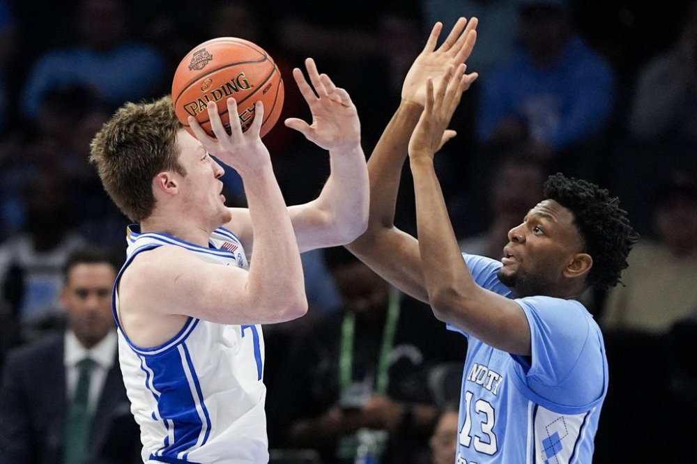 Duke guard Kon Knueppel shoots over North Carolina forward Jalen Washington during the first half of an NCAA college basketball game in the semifinals of the Atlantic Coast Conference tournament, Friday, March 14, 2025, in Charlotte, N.C. (AP Photo/Chris Carlson)