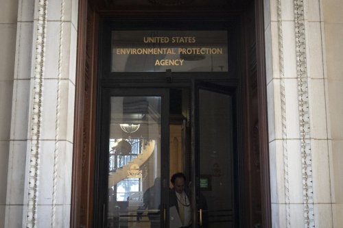 A person exits the headquarters building of the Environmental Protection Agency Wednesday, March 12, 2025, in Washington. (AP Photo/Mark Schiefelbein)