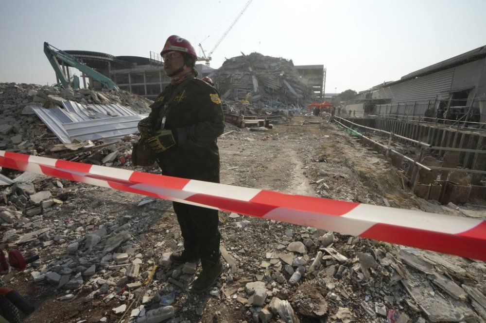 A rescuer walks at the site of a high-rise building under construction that collapsed after a 7.7 magnitude earthquake in Bangkok, Thailand, Friday, March 28, 2025. (AP Photo/Sakchai Lalit)