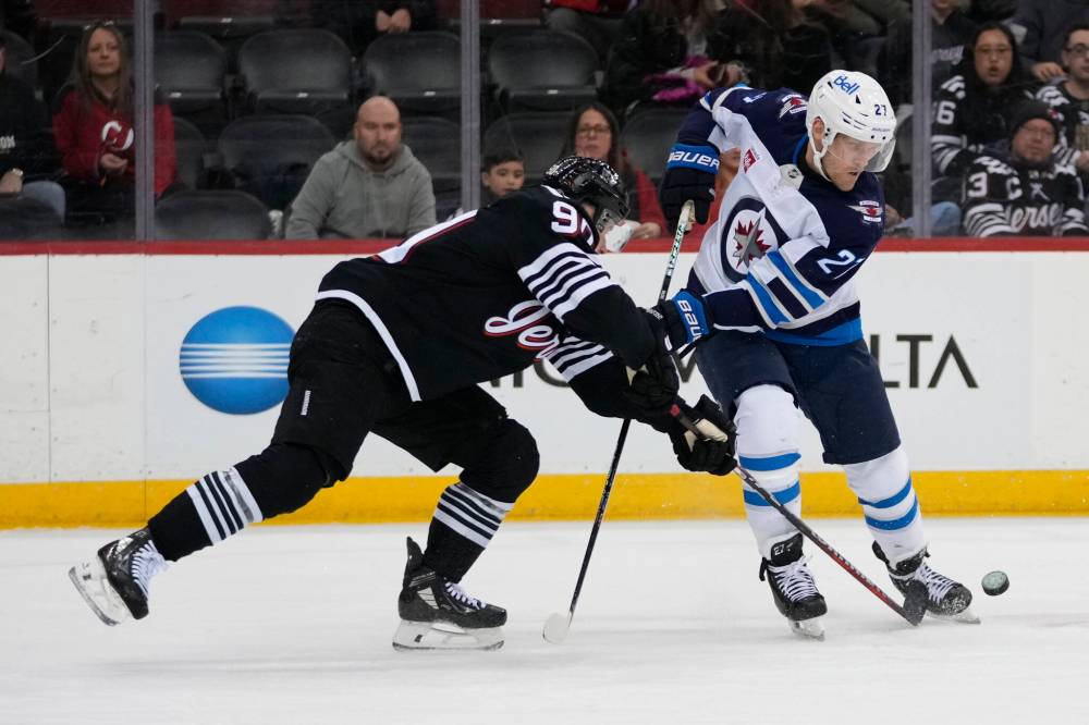 Frank Franklin II / The Associated Press
New Jersey Devils’ Tomas Tatar, left, fights for control of the puck with Winnipeg Jets’ Nikolaj Ehlers during the first period.