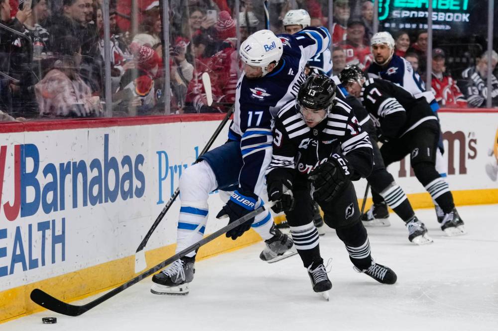 Frank Franklin II / The Associated Press
New Jersey Devils’ Nico Hischier battles along the boards with Winnipeg Jets’ Adam Lowry during the third period.