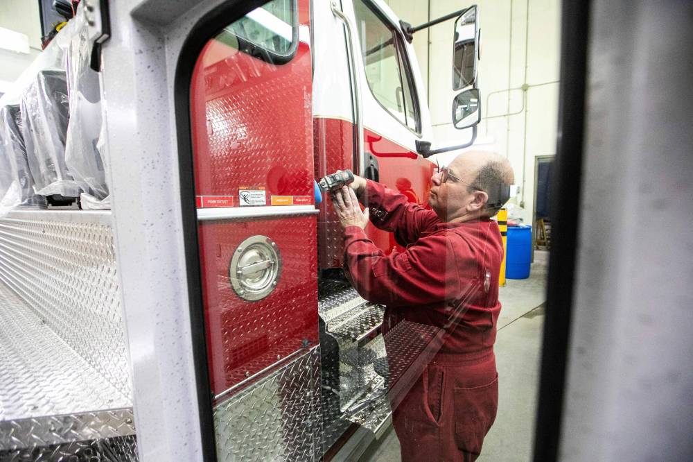 MIKAELA MACKENZIE / FREE PRESS
Dave Felske, paint booth team lead, buffs a finished truck as part of the detailing process at Fort Garry Fire Trucks on Thursday.