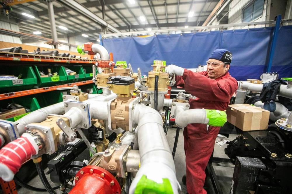 MIKAELA MACKENZIE / FREE PRESS
Mechanic Emmanuel Ponce works on a pump, the key component for fire trucks.