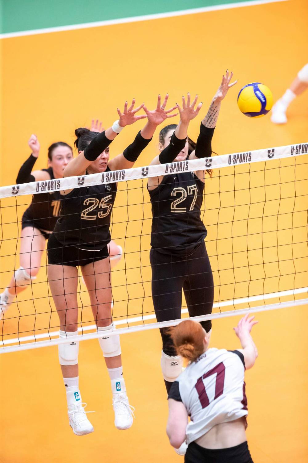 ROOK JONES / FREE PRESS
U of M’s Raya Surinx (left) and Brenna Bedosky (No. 27) attempt to block a spike by Saint Mary’s Huskies’ Emilia Mikanovich.