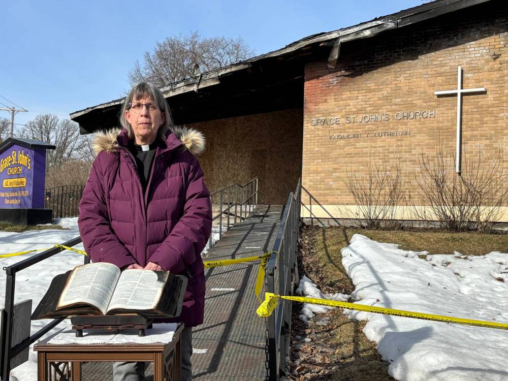 Pastor Trudy Thorarinson stands in front of Grace-St. John’s Anglican Lutheran Church in Carman after leading parishioners in a short time of ‘blessing and farewell’ to the building Sunday. The church was damaged in a fire Thursday. (Aaron Epp / Free Press)