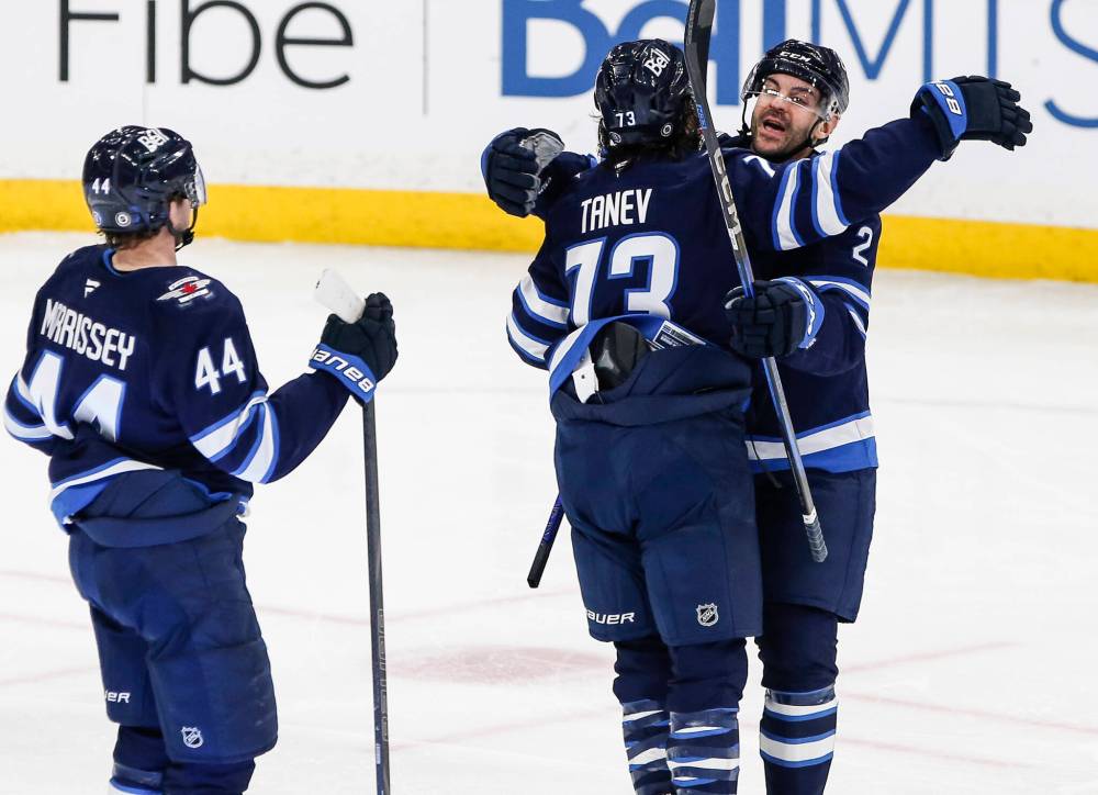 Brandon Tanev (centre) celebrates Morgan Barron’s goal against the Dallas Stars at Canada Life Centre on Friday night with teammates Josh Morrissey (left) and Dylan DeMelo. (John Woods / The Canadian Press)