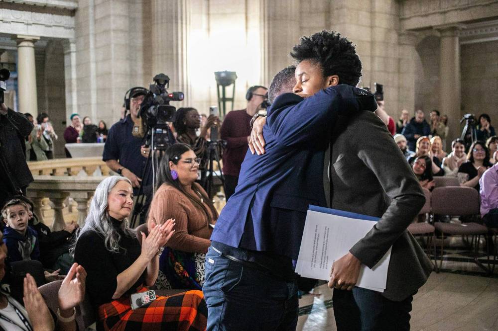 MIKAELA MACKENZIE / FREE PRESS
Health minister Uzoma Asagwara (right) hugs MLA Logan Oxenham during the event. Oxenham introduced the bill last year to make official the March 31 day of visibility.
