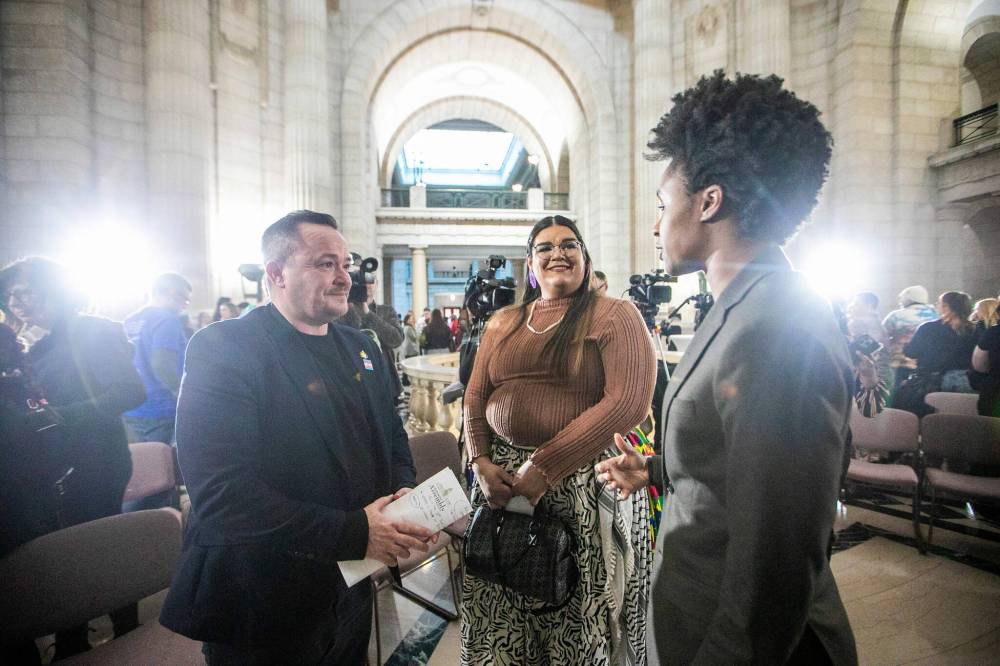 MIKAELA MACKENZIE / FREE PRESS
MLA Logan Oxenham (left), community member Feather Wolfe, and health minister Uzoma Asagwara chat at an event celebrating the first two-spirit and transgender day of visibility at the Manitoba Legislative Building on Monday.