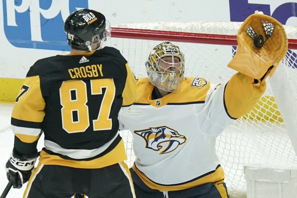 FILE - Nashville Predators goaltender Juuse Saros, right, makes a save in front of Pittsburgh Penguins' Sidney Crosby (87) during the first period of an NHL hockey game, April 15, 2024, in Pittsburgh. (AP Photo/Matt Freed, File)