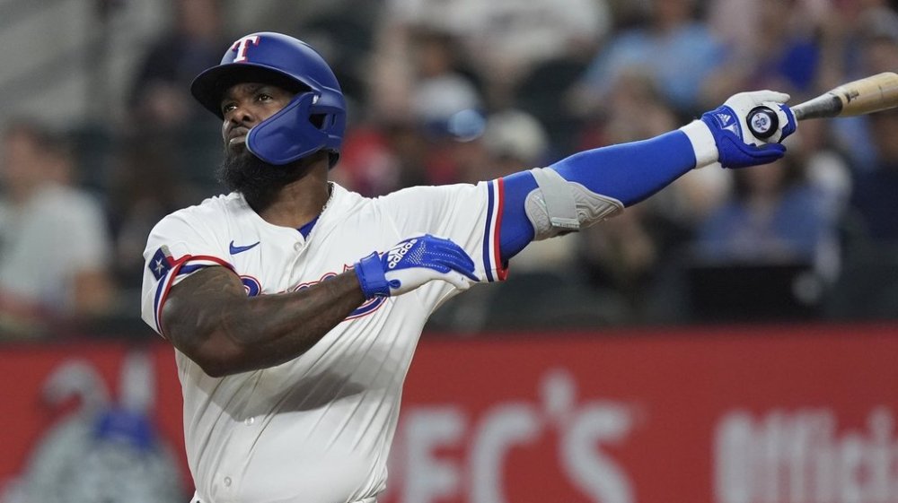 Texas Rangers' Adolis García follows through on a swing during an at-bat in the fourth inning of a baseball game against the Boston Red Sox, Saturday, March 29, 2025, in Arlington, Texas. (AP Photo/LM Otero)
