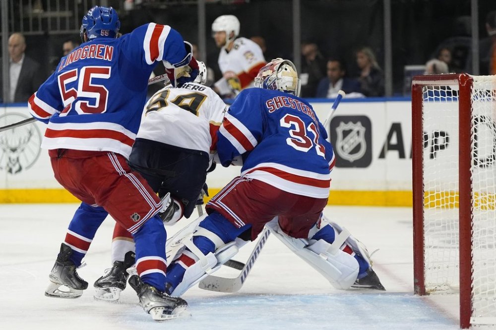 FILE - Florida Panthers left wing Ryan Lomberg (94) collides with New York Rangers goaltender Igor Shesterkin (31) as New York Rangers defenseman Ryan Lindgren (55) helps defend during the third period of Game 1 of the NHL hockey Eastern Conference Stanley Cup playoff finals, May 22, 2024, in New York. Lomberg was called for goalie interference negating a goal scored by the Panthers on the play. (AP Photo/Julia Nikhinson, File)