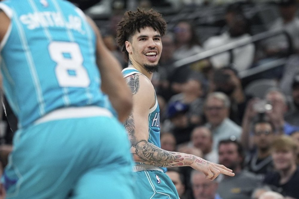 Charlotte Hornets guard LaMelo Ball (1) reacts to a score against the San Antonio Spurs during the second half of an NBA basketball game in San Antonio, Friday, March 14, 2025. (AP Photo/Eric Gay)