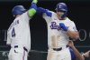 Texas Rangers' Wyatt Langford, right, celebrates his home run with teammate Joc Pederson (4) during the seventh inning of a baseball game against the Tampa Bay Rays, Saturday, April 5, 2025, in Arlington, Texas. (AP Photo/LM Otero)