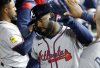 Atlanta Braves' Michael Harris II is congratulated in the dugout after hitting a one-run home run against the Los Angeles Dodgers during the eight inning of a baseball game Monday, March 31, 2025, in, Los Angeles. (AP Photo/Kevork Djansezian)