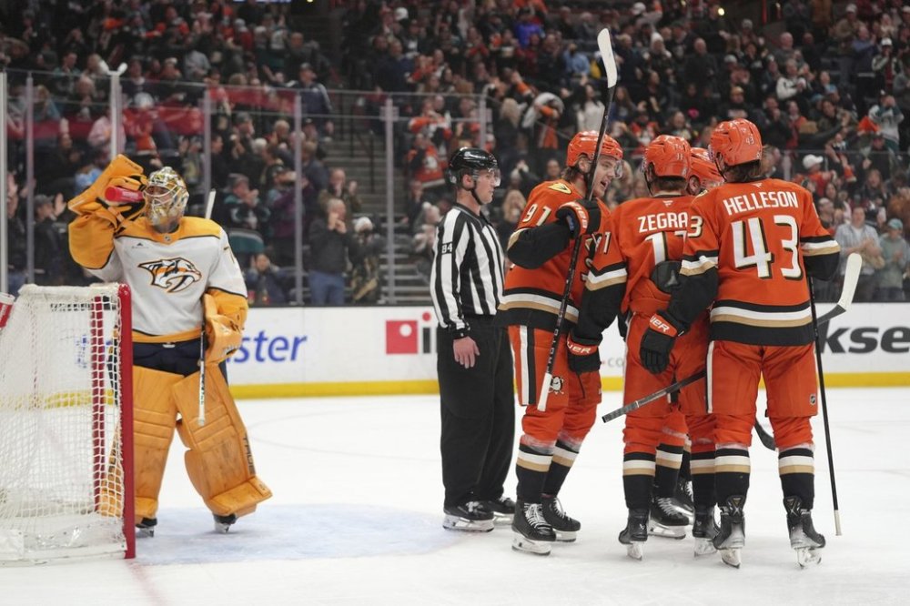 Anaheim Ducks players celebrate a goal by Alex Killorn in front of Nashville Predators goaltender Juuse Saros during the third period of an NHL hockey game Friday, March 14, 2025, in Anaheim, Calif. (AP Photo/Jae C. Hong)