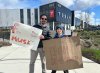 Juan Alperin and his son Milo, 12, attend a protest at a Tesla dealership in Surrey, B.C. on Sunday, March 16, 2025. THE CANADIAN PRESS/Brenna Owen