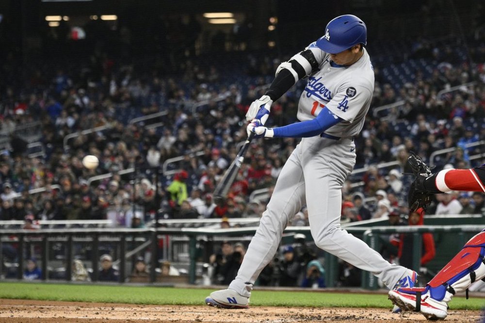 Los Angeles Dodgers designated hitter Shohei Ohtani hits a two-run home run during the third inning of a baseball game against the Washington Nationals, Monday, April 7, 2025, in Washington. (AP Photo/Nick Wass)