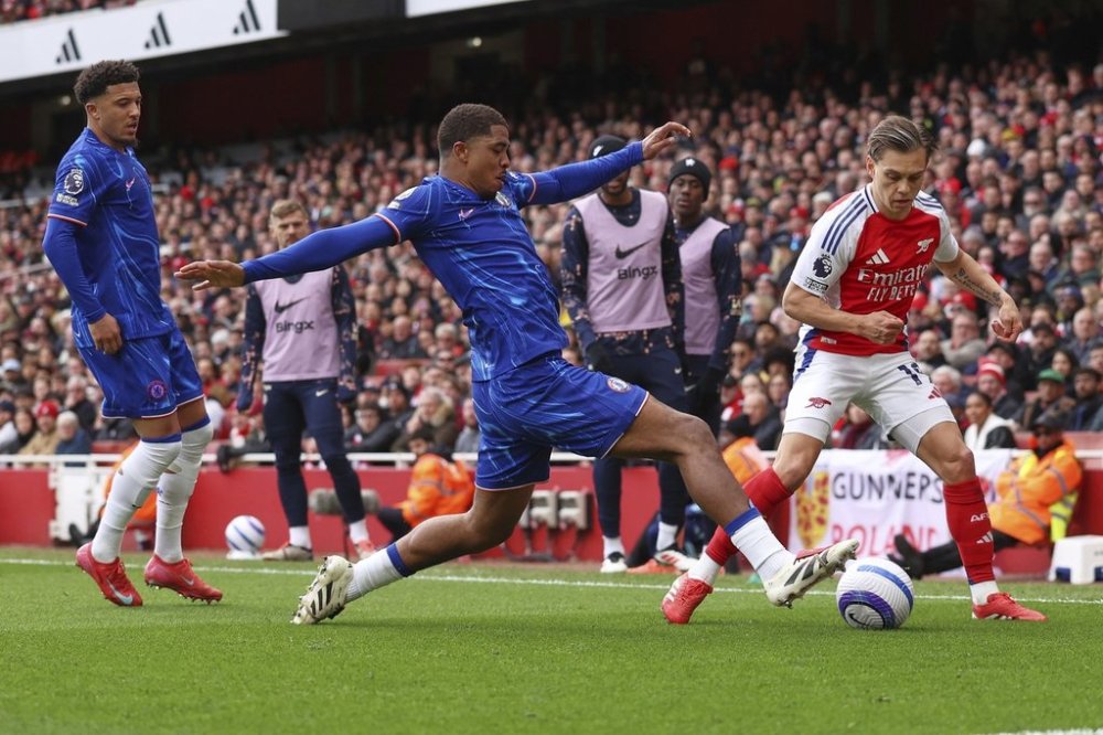 Chelsea's Wesley Fofana, centre, challenges for the ball with Arsenal's Leandro Trossard during the English Premier League soccer match between Arsenal and Chelsea at Emirates stadium in London, Sunday, March 16, 2025. (AP Photo/Ian Walton)