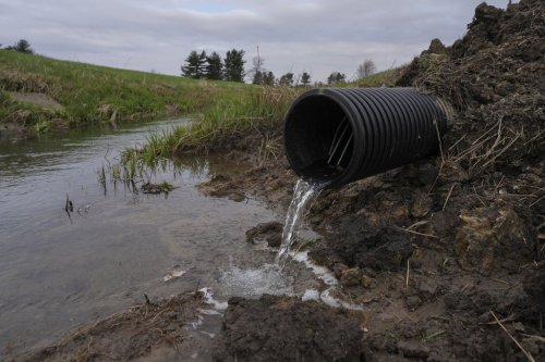 FILE - Water runs out of a drain under an agricultural field, Tuesday, April 9, 2024, in Sabina, Ohio. (AP Photo/Joshua A. Bickel, File)