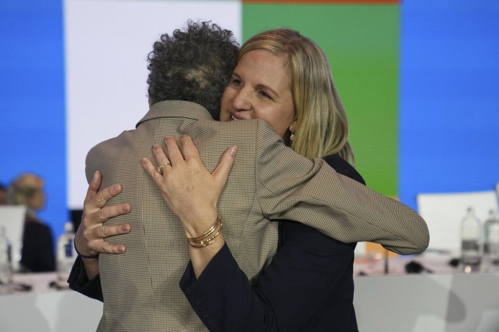 Kirsty Coventry, right, is embraced by Anita Defrantz after she was announced as the new IOC President at the International Olympic Committee 144th session in Costa Navarino, western Greece, Thursday, March 20, 2025. (AP Photo/Thanassis Stavrakis)