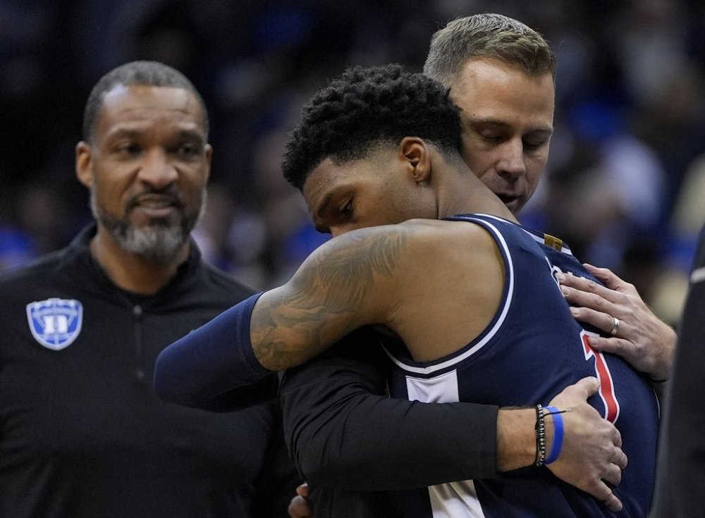 Arizona guard Caleb Love (1) hugs Duke head coach Jon Scheyer after Arizona lost to Duke in a Sweet 16 round NCAA college basketball tournament game, Friday, March 28, 2025, in Newark, N.J. (AP Photo/Julia Demaree Nikhinson)