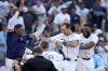 Tampa Bay Rays' Kameron Misner, second from right, celebrates with Christopher Morel, left, Jonny DeLuca and Junior Caminero after hitting a walk-off home run off Colorado Rockies pitcher Victor Vodnik during the ninth inning of a baseball game Friday, March 28, 2025, in Tampa, Fla. (AP Photo/Chris O'Meara)