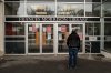 A person reads signs at an entrance to the closed Frances Morrison Central Library in Saskatoon on Monday, March 24, 2025. The head of the city's only safe consumption site says she saw the current drug crisis coming. THE CANADIAN PRESS/Liam Richards