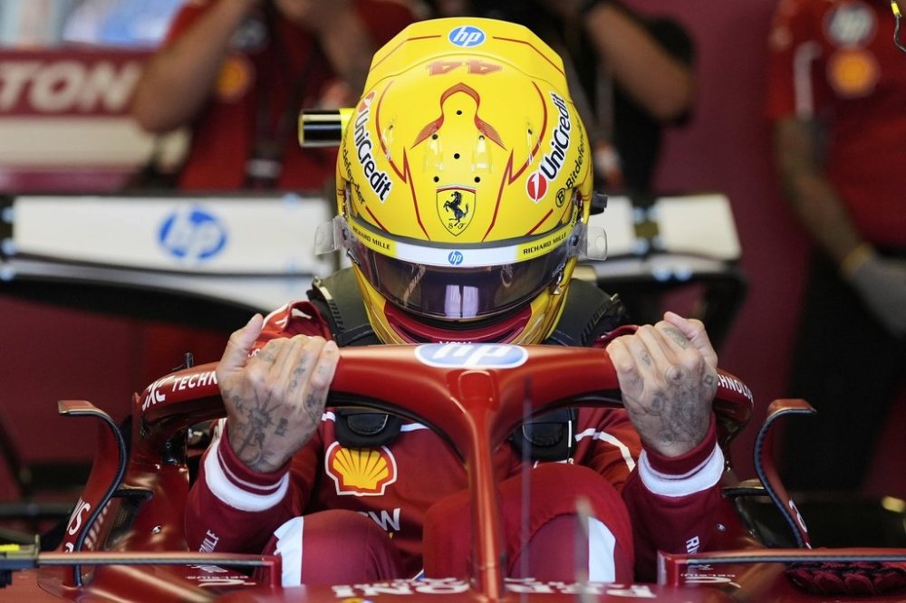 Ferrari driver Lewis Hamilton of Britain gets into his car for the first practice session for the Australian Formula One Grand Prix at Albert Park, in Melbourne, Australia, Friday, March 14, 2025. (AP Photo/Asanka Brendon Ratnayake)