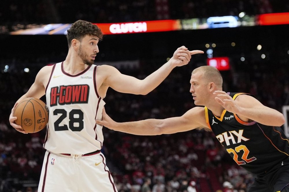 Houston Rockets' Alperen Sengun (28) points over Phoenix Suns' Mason Plumlee (22) during the first half of an NBA basketball game Wednesday, March 12, 2025, in Houston. (AP Photo/David J. Phillip)
