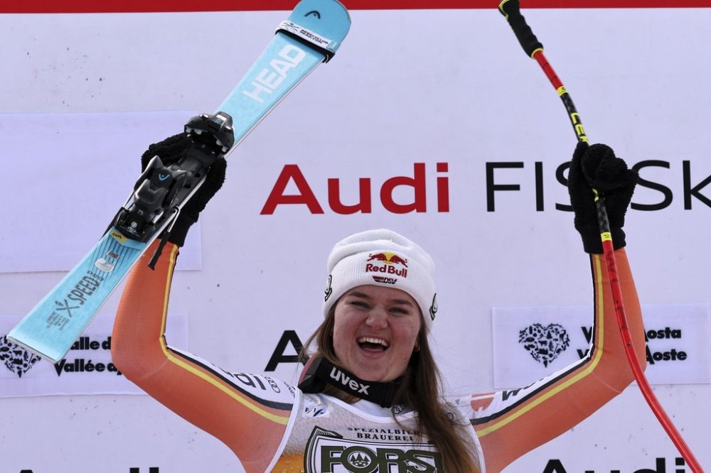 The winner Germany's Emma Aicher celebrates after an alpine ski, women's World Cup super G race, in La Thuile, Italy, Thursday, March 13, 2025. (AP Photo/Marco Trovati)