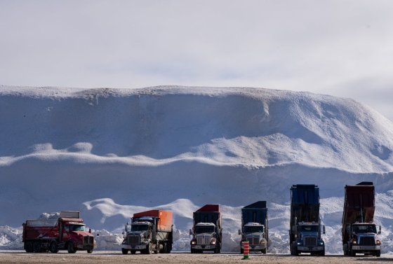 Trucks drop their loads of snow at the Angrignon snow deposit site in Montreal in February. (Christinne Muschi / The Canadian Oress files)
