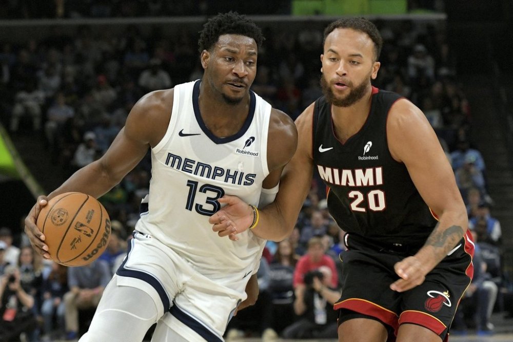 Memphis Grizzlies forward Jaren Jackson Jr. (13) handles the ball against Miami Heat forward Kyle Anderson (20) in the first half of an NBA basketball game Saturday, March 15, 2025, in Memphis, Tenn. (AP Photo/Brandon Dill)