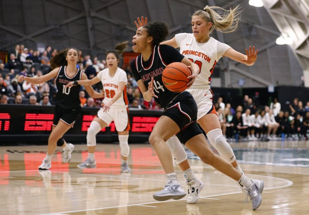FILE - Harvard guard Harmoni Turner (14) drives to the basket against Princeton forward Ellie Mitchell (00) during the first half of the Ivy League championship NCAA college basketball game, Saturday, March 11, 2023, in Princeton, N.J. (AP Photo/Noah K. Murray, File)