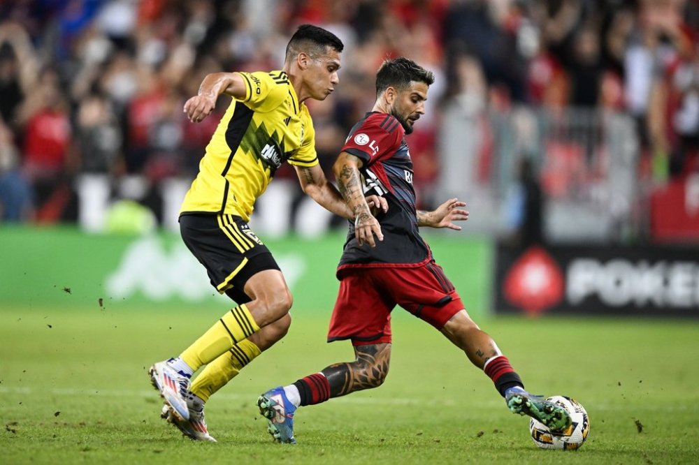 Toronto FC forward Lorenzo Insigne (24) is defended by Columbus Crew defender Andres Herrera, during first half MLS soccer action, in Toronto on Wednesday, September 18, 2024. THE CANADIAN PRESS/Chris Katsarov