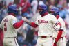 Philadelphia Phillies' Nick Castellanos, center, celebrates with Bryce Harper (3) after hitting a grand slam off Los Angeles Dodgers' Alex Vesia during the third inning of a baseball game, Sunday, April 6, 2025, in Philadelphia. (AP Photo/Derik Hamilton)