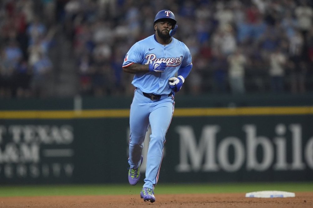 Texas Rangers' Adolis García runs the bases after hitting a home run during the sixth inning of a baseball game against the Boston Red Sox, Sunday, March 30, 2025, in Arlington, Texas. (AP Photo/LM Otero)