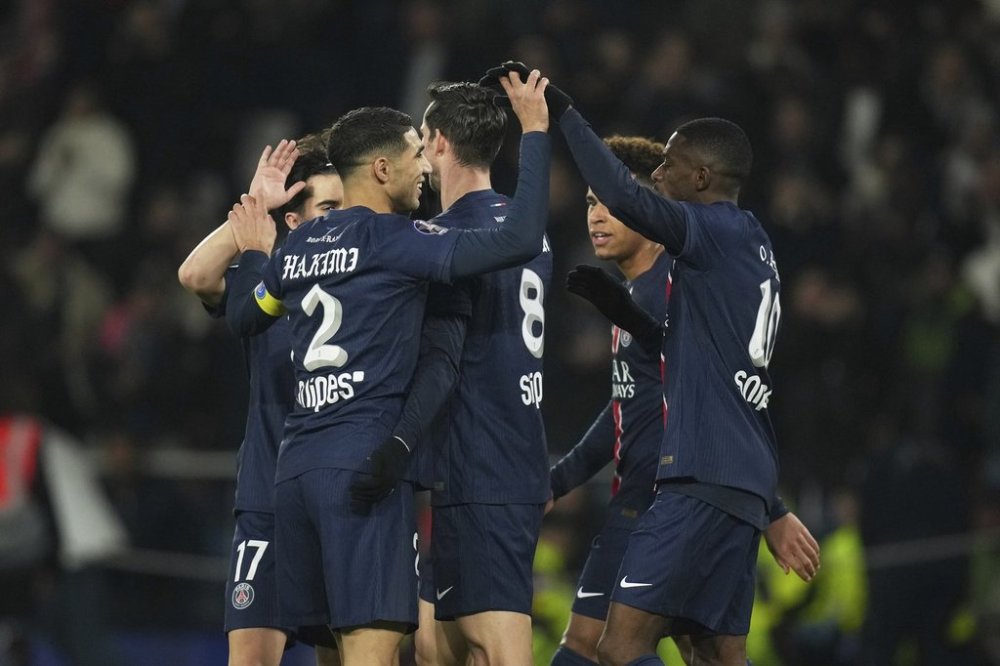 PSG's players celebrate after PSG's Nuno Mendes scored his side's second goal during the French League One soccer match between Paris Saint Germain and Marseille at Parc des Princes stadium in Paris, Sunday, March 16, 2025. (AP Photo/Christophe Ena)