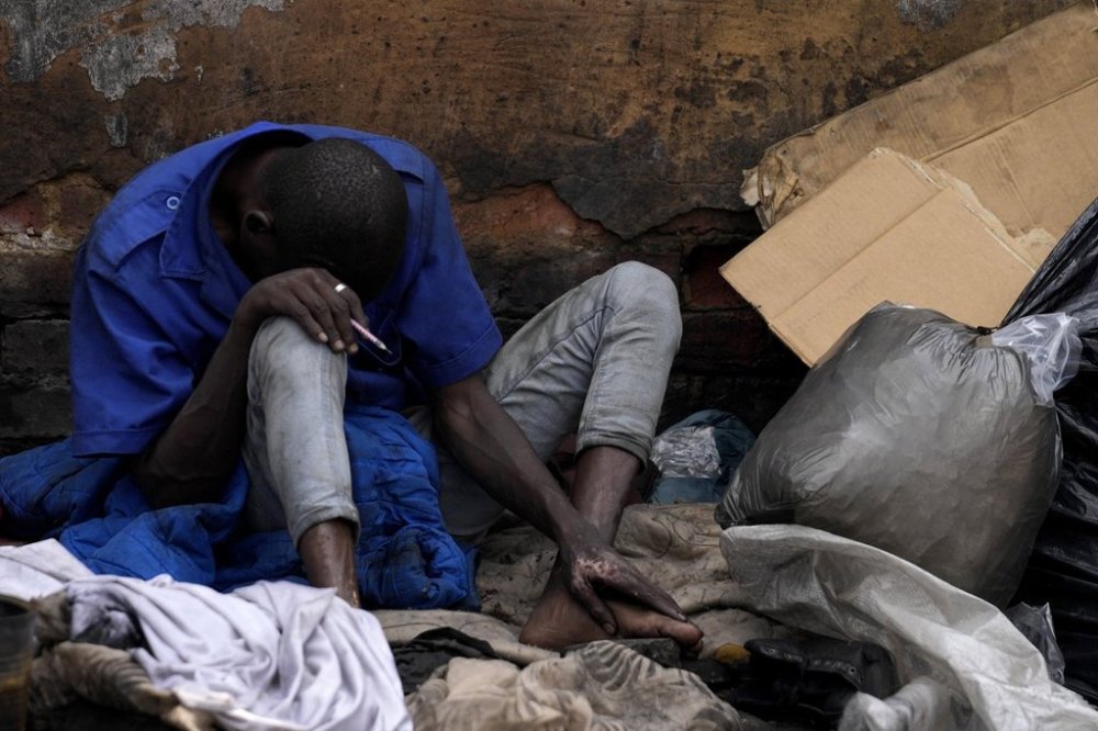 A homeless drug addict holds a syringe after injecting himself, on the outskirts of Pretoria, South Africa, Wednesday, March 5, 2025. (AP Photo/Themba Hadebe)