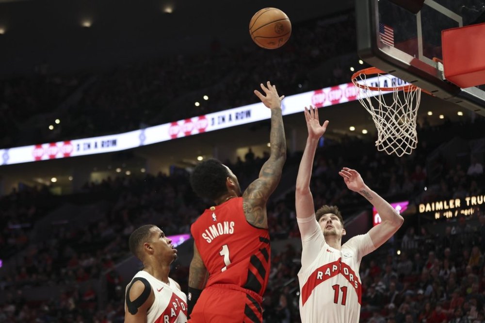 Portland Trail Blazers guard Anfernee Simons, centre, shoots over Toronto Raptors centre Orlando Robinson, left, and centre Colin Castleton, right, during the first half of an NBA basketball game Sunday, March 16, 2025, in Portland, Ore. (AP Photo/Amanda Loman)