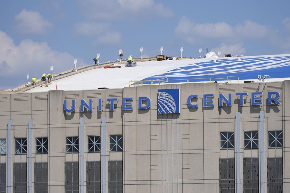 Workers are seen on the roof of the United Center in preparation for the 2024 Democratic National Convention in Chicago, Aug. 13, 2024. (AP Photo/Pablo Martinez Monsivais, File)