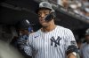 New York Yankees's Aaron Judge (99) celebrates in the dugout after hitting a two-run home run in the fourth inning of a baseball game against the Milwaukee Brewers, Saturday, March 29, 2025, in New York. (AP Photo/Angelina Katsanis)