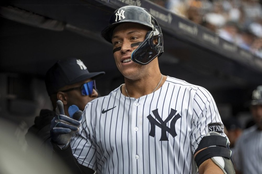 New York Yankees's Aaron Judge (99) celebrates in the dugout after hitting a two-run home run in the fourth inning of a baseball game against the Milwaukee Brewers, Saturday, March 29, 2025, in New York. (AP Photo/Angelina Katsanis)